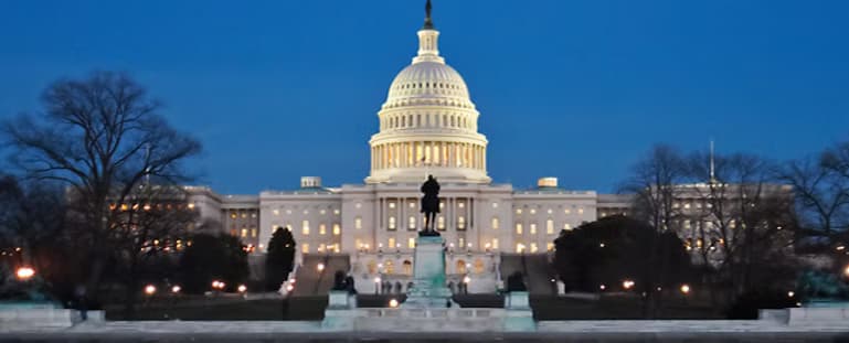 The United States Capitol lit against a deep blue evening sky